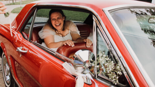 Bride in red car